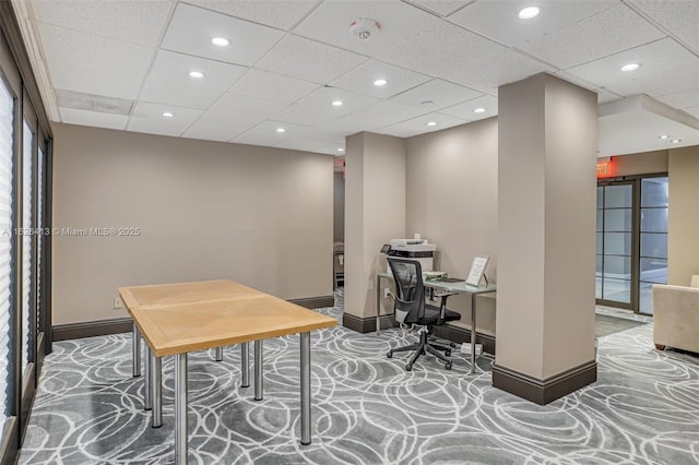 carpeted home office featuring a drop ceiling