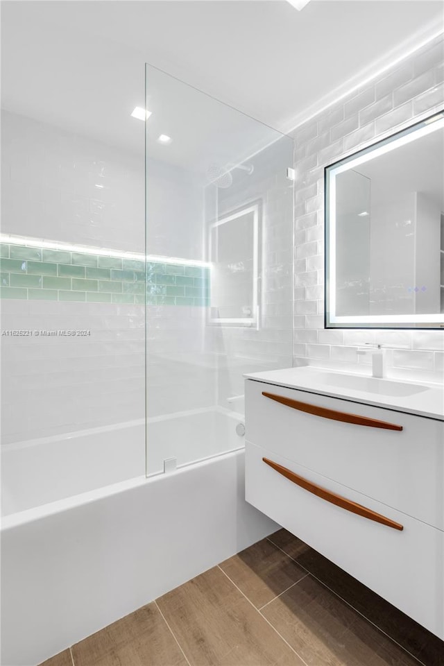 bathroom featuring vanity, shower / bath combination, tile walls, and wood-type flooring