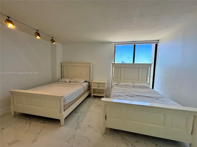 bedroom with track lighting and a textured ceiling