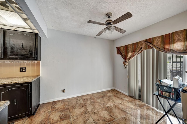 interior space with ceiling fan and a textured ceiling