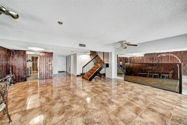 living room featuring a textured ceiling and ceiling fan