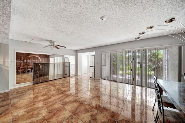 unfurnished living room with ceiling fan