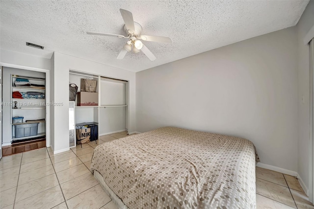 bedroom featuring a closet, a textured ceiling, tile patterned flooring, and ceiling fan