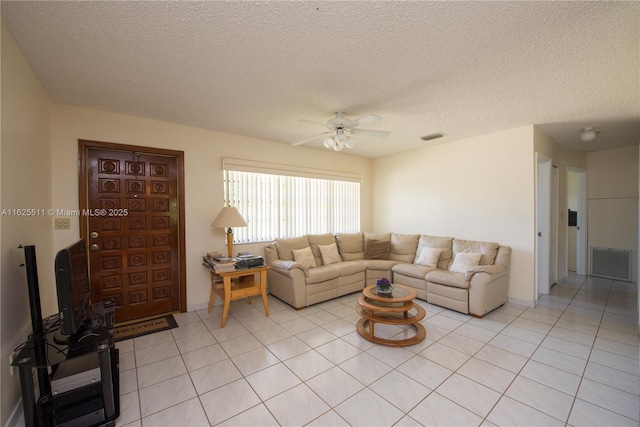 living room with ceiling fan, a textured ceiling, and light tile patterned floors