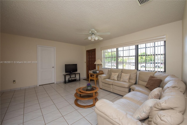 living room with ceiling fan, light tile patterned floors, and a textured ceiling