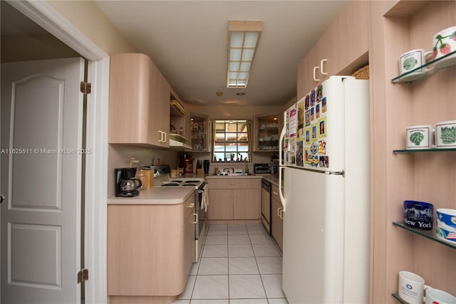 kitchen featuring light tile patterned floors, sink, electric range, light brown cabinetry, and white fridge