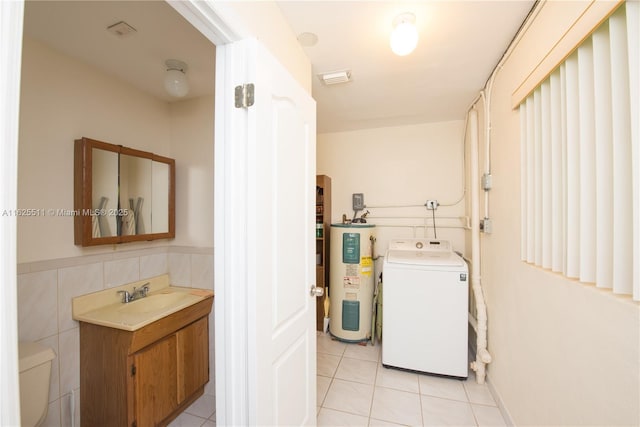 laundry room with washer / clothes dryer, sink, water heater, and light tile patterned floors