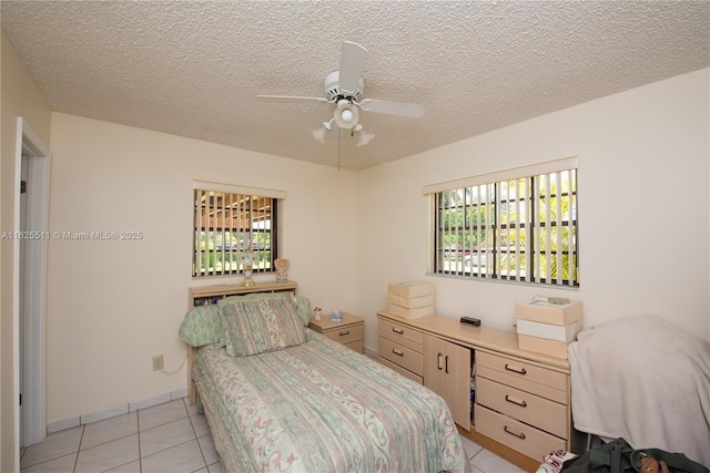 bedroom with light tile patterned floors, a textured ceiling, and ceiling fan