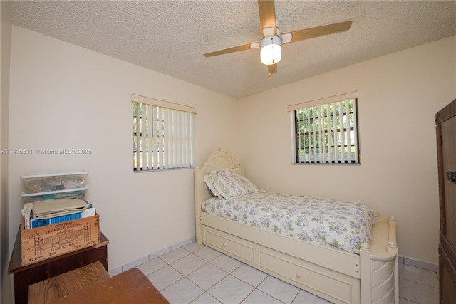 bedroom with light tile patterned floors, a textured ceiling, and ceiling fan