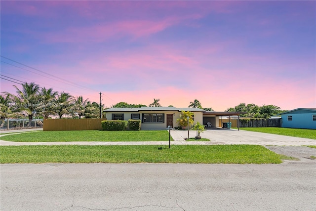 ranch-style house with a carport and a yard