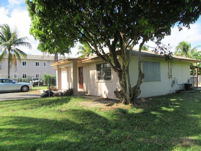 view of front of property with central AC and a front lawn