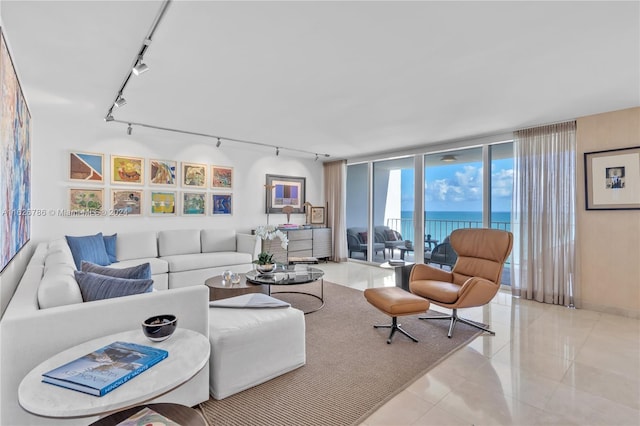 living room featuring a water view, track lighting, floor to ceiling windows, and light tile patterned floors