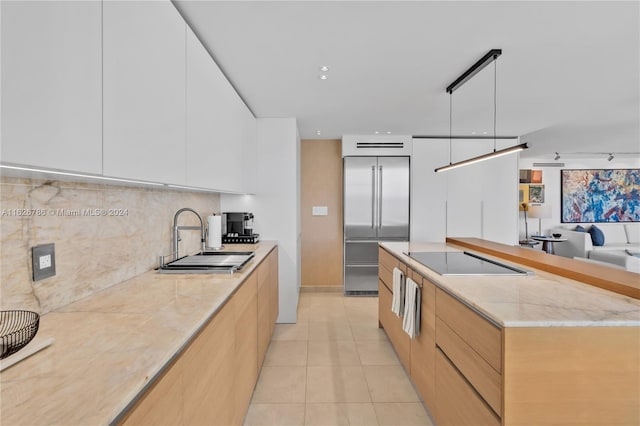 kitchen featuring light tile patterned flooring, built in refrigerator, pendant lighting, black electric stovetop, and white cabinets