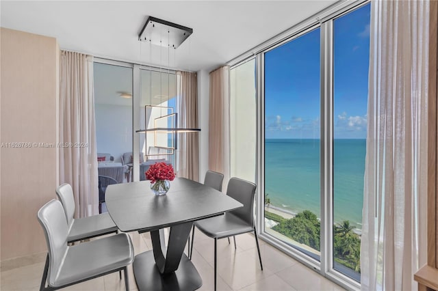 tiled dining space with floor to ceiling windows and a water view