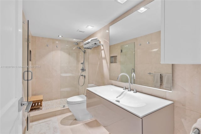 bathroom featuring tile walls, vanity, walk in shower, toilet, and tile patterned floors