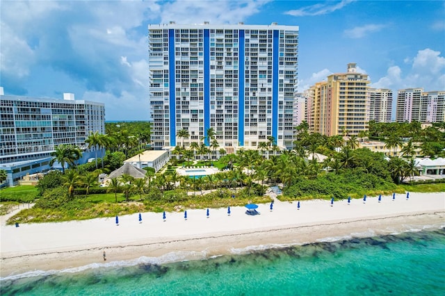 view of building exterior with a water view and a view of the beach