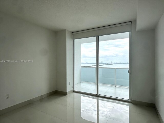 unfurnished room featuring light tile patterned floors and expansive windows