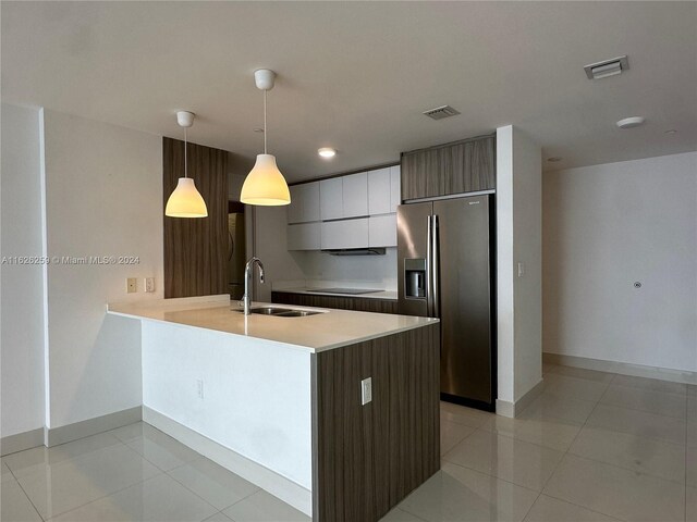 kitchen featuring pendant lighting, sink, stainless steel fridge with ice dispenser, light tile patterned floors, and black electric cooktop