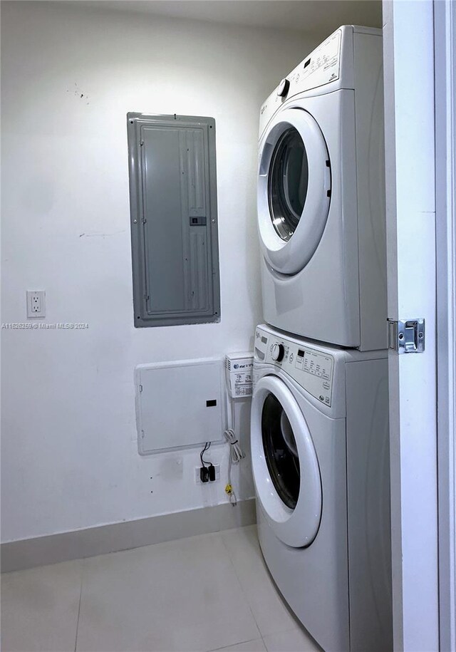 washroom featuring tile patterned floors, electric panel, and stacked washer / dryer