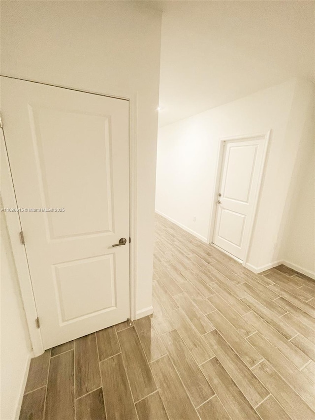 empty room featuring baseboards and wood tiled floor