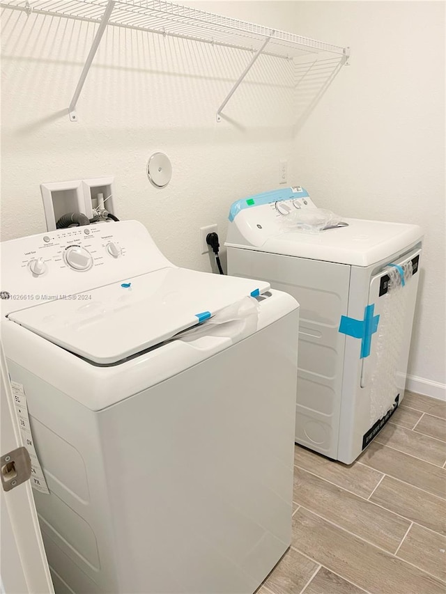 laundry area featuring washing machine and dryer and light wood-type flooring