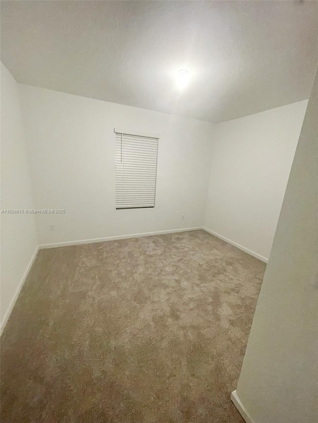 carpeted empty room with baseboards