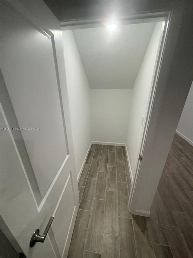 corridor with wood finish floors and baseboards