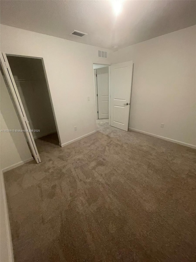 unfurnished bedroom featuring carpet, visible vents, and baseboards