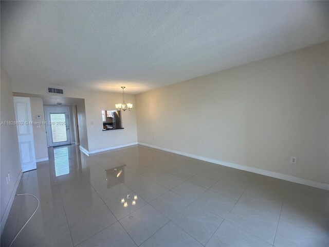 unfurnished dining area with a textured ceiling and light tile patterned floors