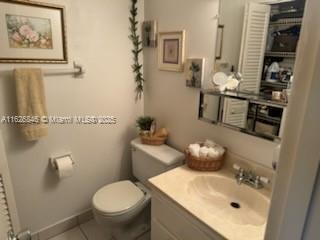 bathroom featuring vanity, tile patterned floors, and toilet