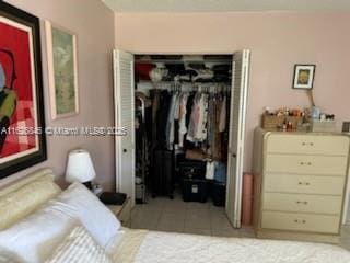 bedroom featuring light tile patterned flooring and a closet