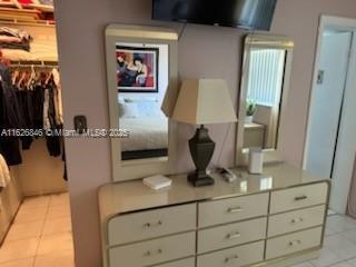 tiled bedroom featuring a spacious closet