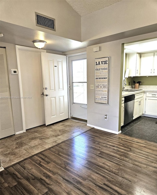 interior space featuring lofted ceiling, dark hardwood / wood-style floors, sink, and a textured ceiling