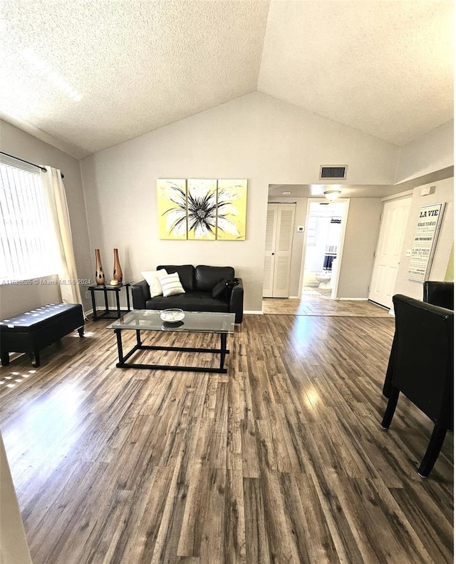 sitting room with wood-type flooring, lofted ceiling, and a textured ceiling