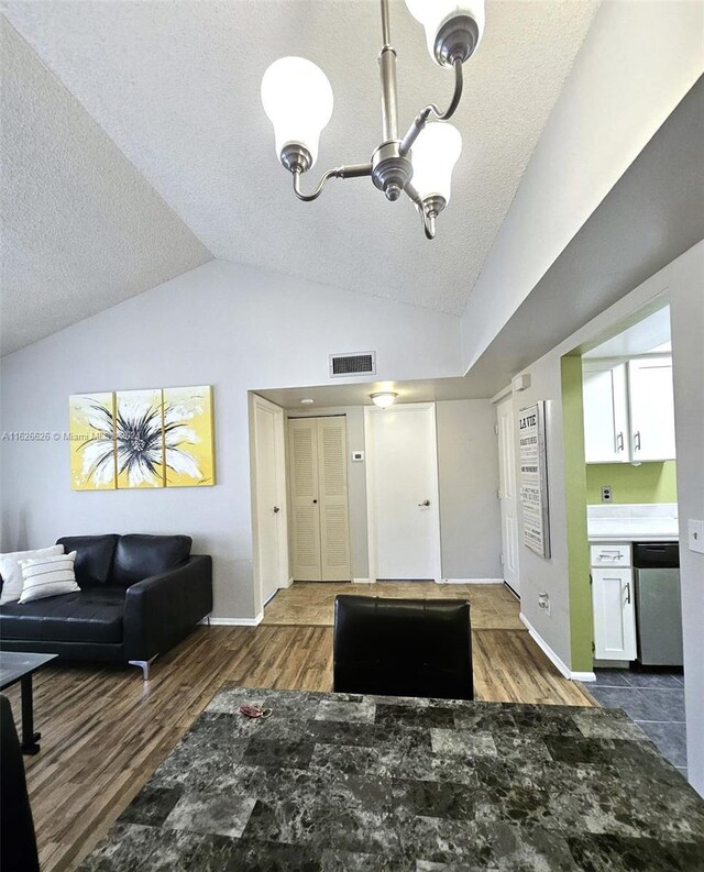 interior space with a textured ceiling, dark hardwood / wood-style flooring, and lofted ceiling