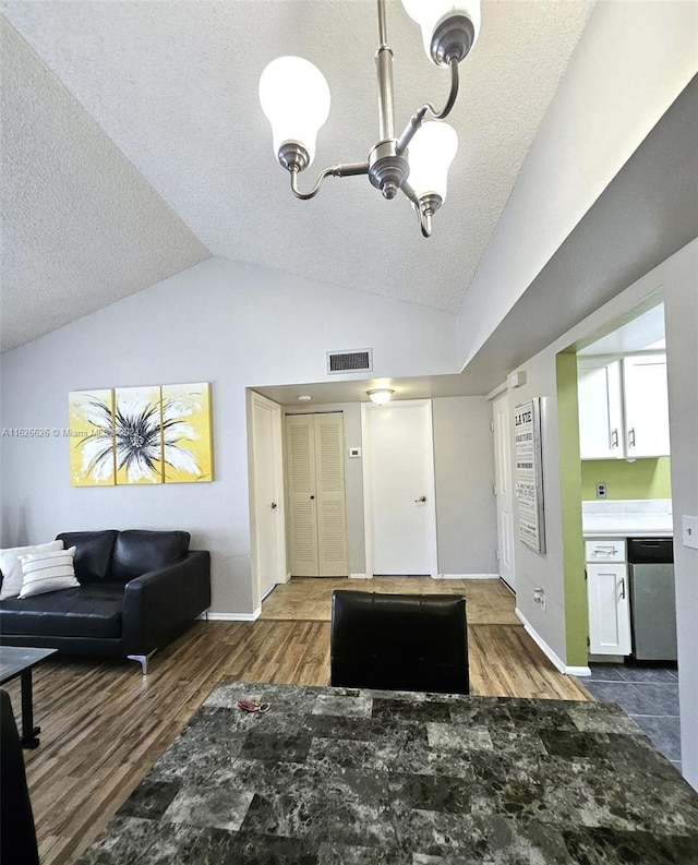 living room featuring dark wood-type flooring, vaulted ceiling, and a textured ceiling