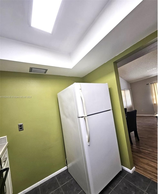 kitchen featuring dark tile patterned floors and white refrigerator