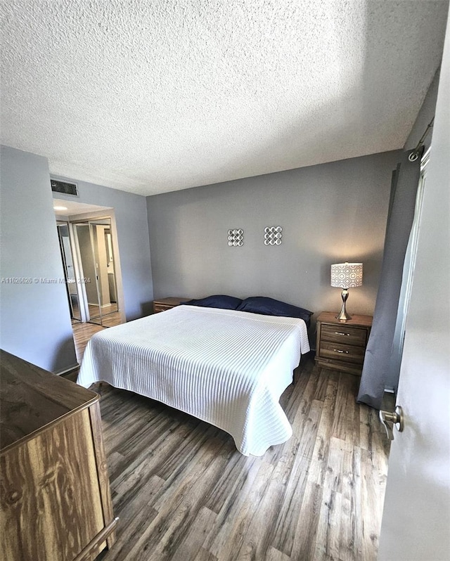 bedroom with hardwood / wood-style floors and a textured ceiling