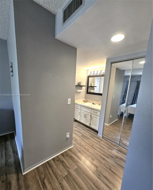 interior space featuring sink, hardwood / wood-style flooring, and a textured ceiling