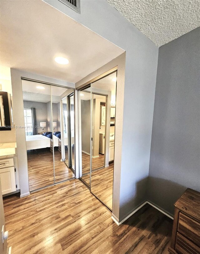 bedroom with a textured ceiling and light wood-type flooring