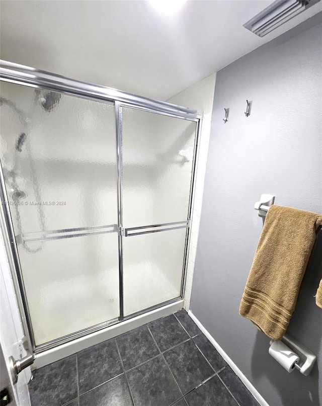 bathroom featuring tile patterned floors and a shower with door