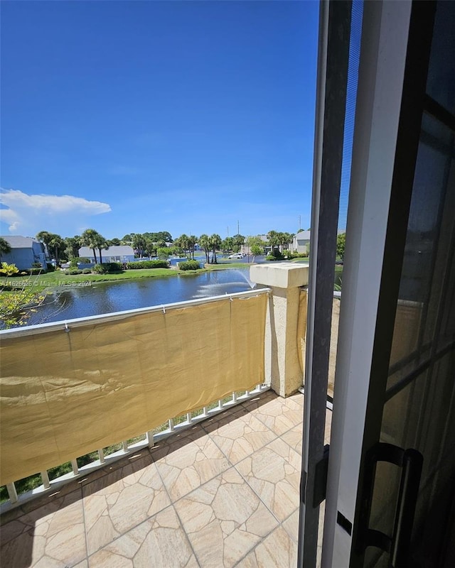 view of patio / terrace with a balcony and a water view