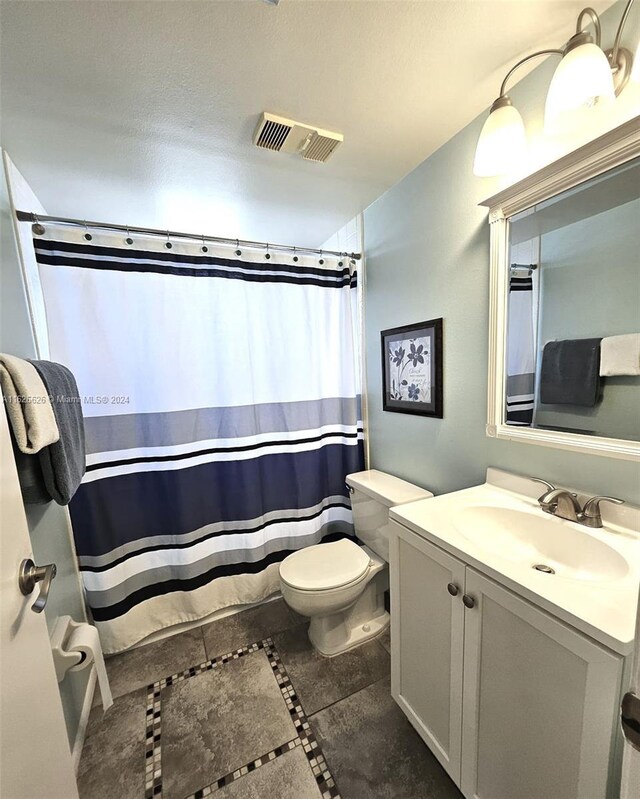 bathroom with vanity, toilet, and tile patterned flooring