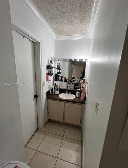 bathroom with vanity, tile patterned flooring, crown molding, and a textured ceiling