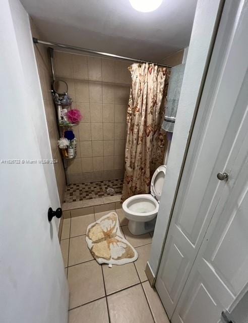 bathroom featuring tile patterned flooring, curtained shower, and toilet