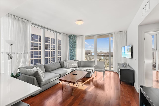 living room featuring dark wood-type flooring, a wall of windows, and plenty of natural light