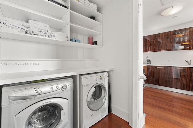 laundry room with sink, washing machine and clothes dryer, and dark hardwood / wood-style flooring