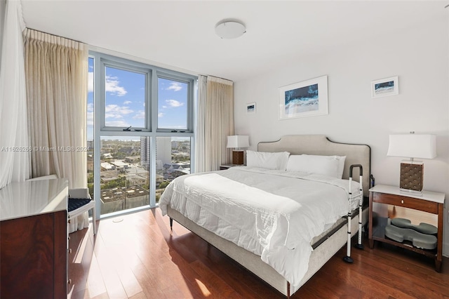 bedroom featuring a wall of windows, dark hardwood / wood-style floors, and access to outside