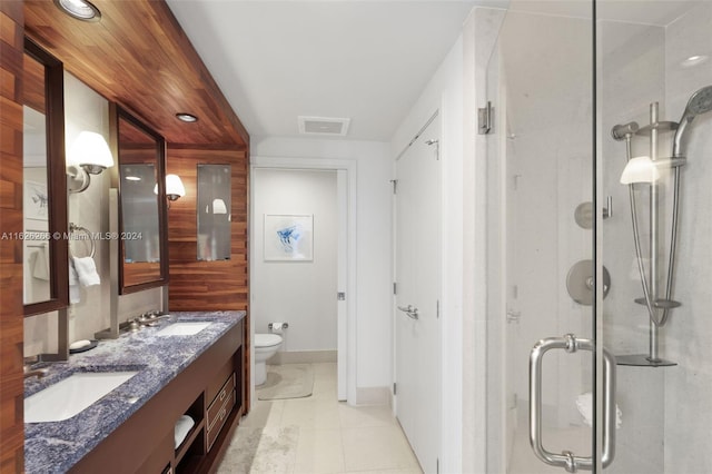 bathroom featuring a shower with door, vanity, tile patterned floors, and toilet