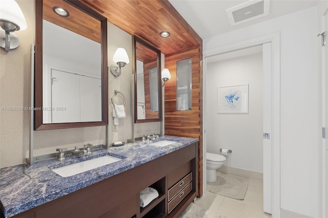 bathroom featuring vanity, tile patterned floors, and toilet